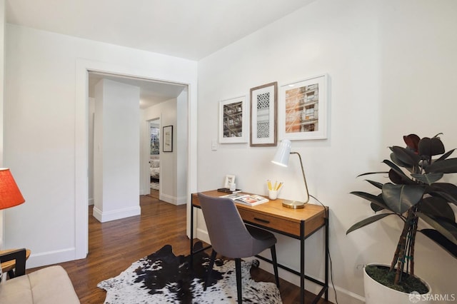 office area with baseboards and dark wood-type flooring