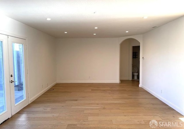 spare room featuring light hardwood / wood-style floors and french doors