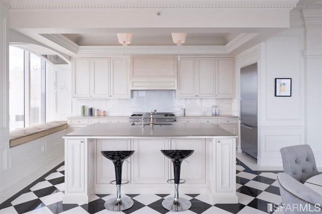 kitchen featuring an island with sink and white cabinets