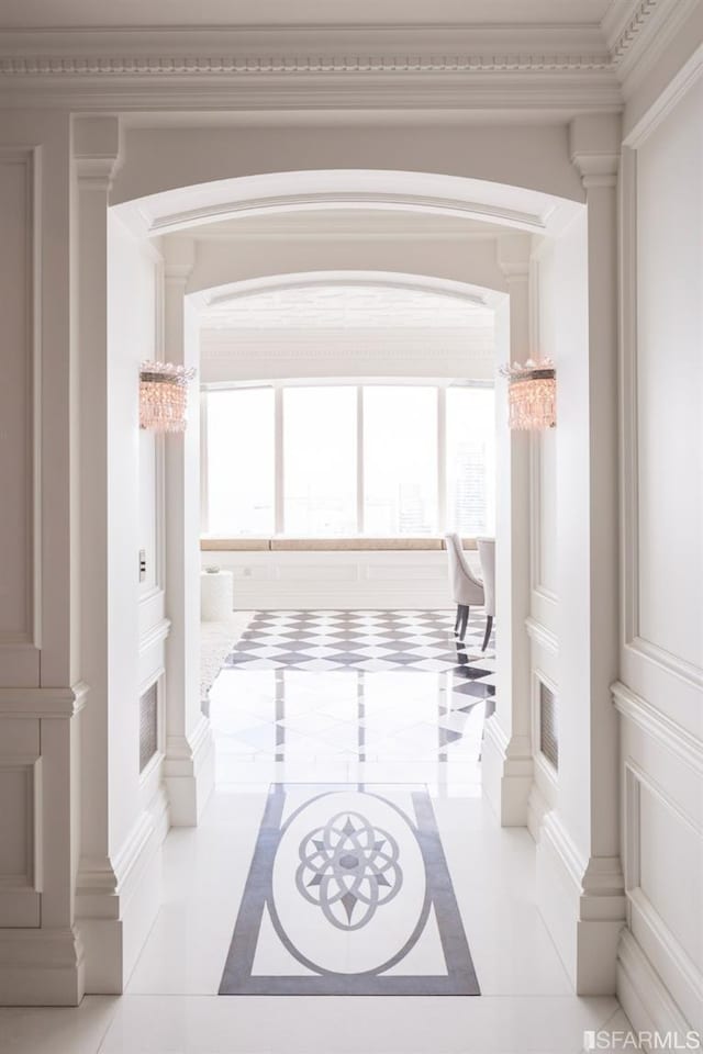 interior space featuring ornamental molding, light tile patterned flooring, and ornate columns