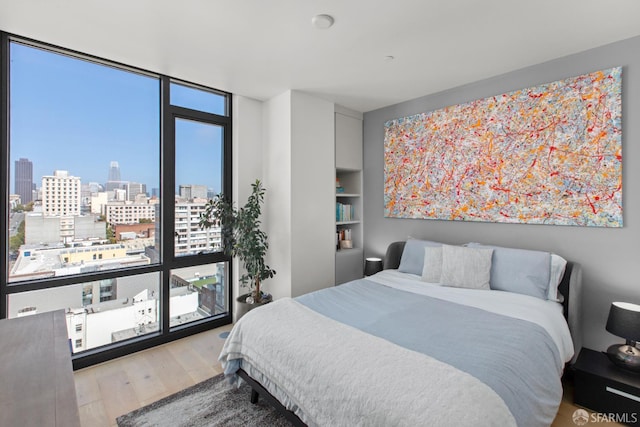 1545 Pine St Unit 1201, San Francisco, CA 94109 - bedroom with wood finished floors, a skyline view, and expansive windows