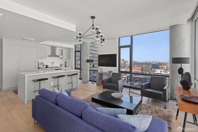 1545 Pine St Unit 1201, San Francisco, CA 94109 - living room featuring light wood-style flooring, a chandelier, and a wall of windows