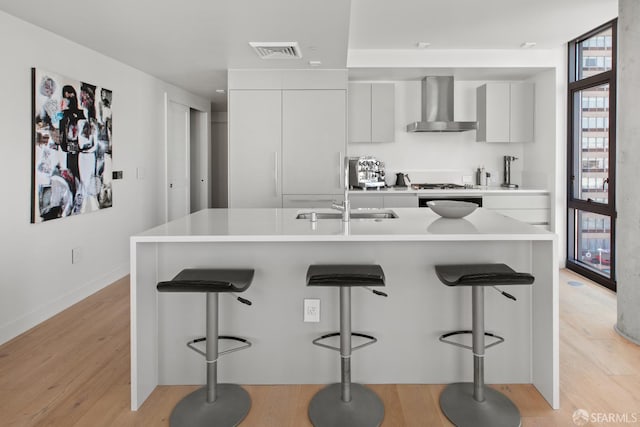 1545 Pine St Unit 1201, San Francisco, CA 94109 - kitchen with wall chimney exhaust hood, modern cabinets, a kitchen breakfast bar, and light countertops