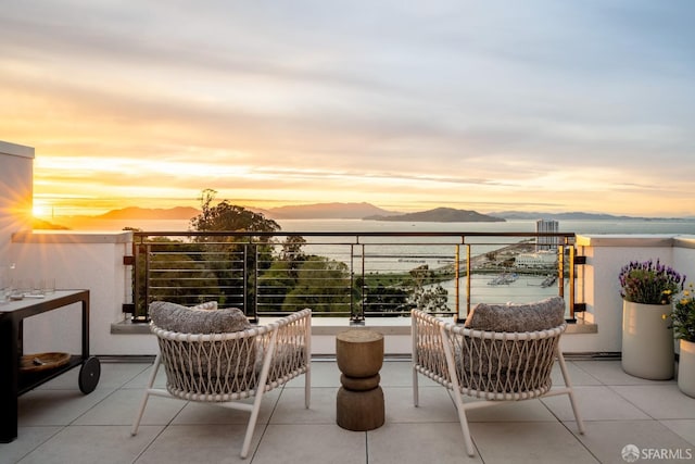 balcony at dusk with a water and mountain view