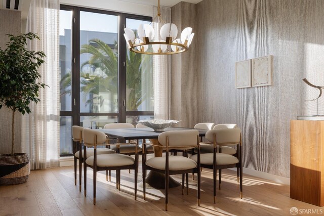 dining area with light hardwood / wood-style flooring and a notable chandelier