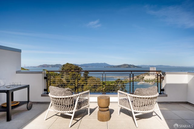 balcony featuring a water and mountain view