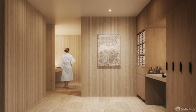 interior space with tile patterned flooring and wood walls