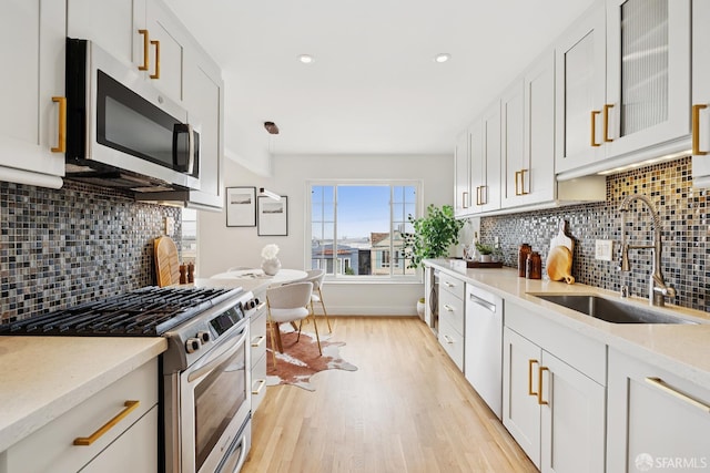 246 Ralston St, San Francisco, CA 94132 - kitchen with stainless steel appliances, light wood-style flooring, decorative backsplash, recessed lighting, and white cabinetry