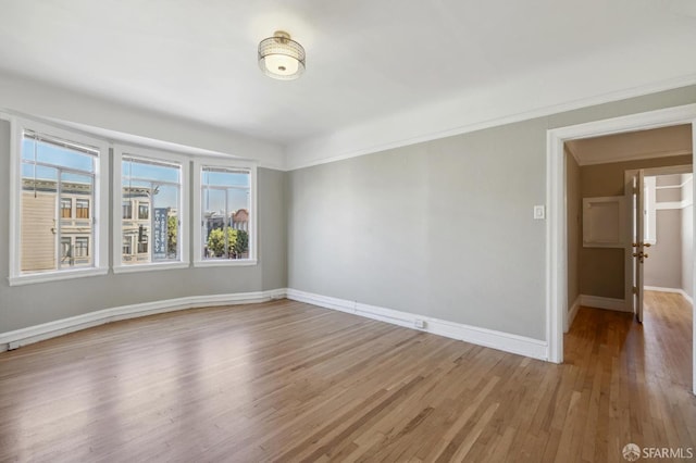 spare room with crown molding and light hardwood / wood-style flooring