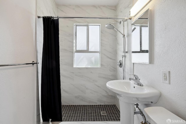 bathroom featuring toilet and curtained shower