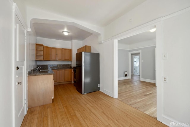 kitchen featuring light hardwood / wood-style flooring, stainless steel fridge, and sink