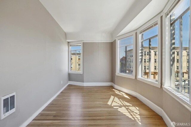 unfurnished room with wood-type flooring