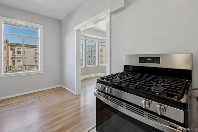 kitchen featuring gas stove, a wealth of natural light, and light wood-type flooring