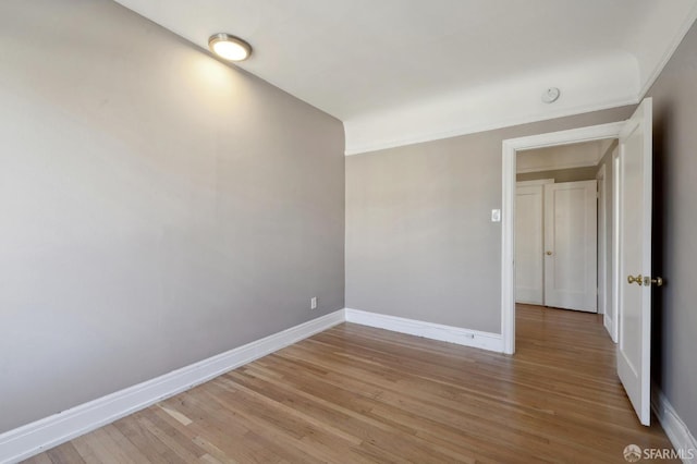 unfurnished room featuring ornamental molding and light hardwood / wood-style floors