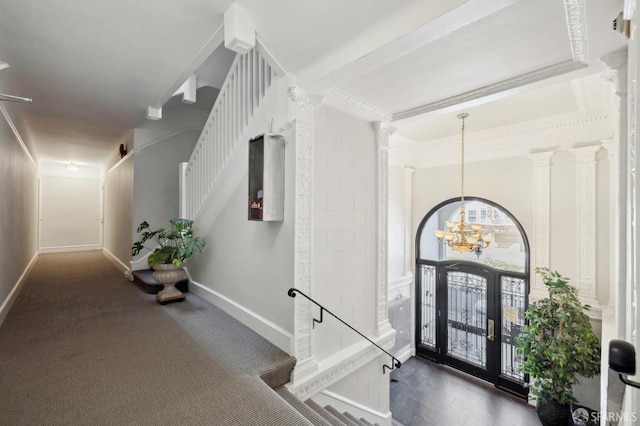 hallway featuring crown molding, an inviting chandelier, and decorative columns