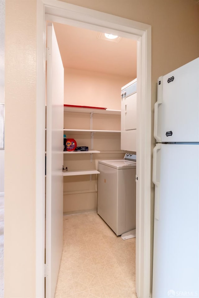 clothes washing area with light tile patterned floors and washer / dryer