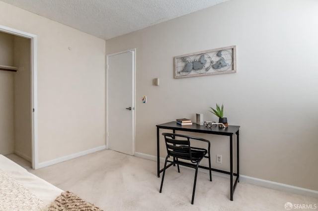 office space with a textured ceiling and light colored carpet