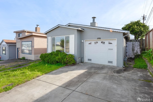 view of front facade featuring fence, a chimney, a garage, concrete driveway, and stucco siding