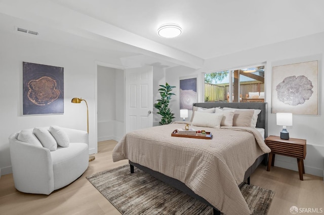 bedroom with light wood finished floors and baseboards