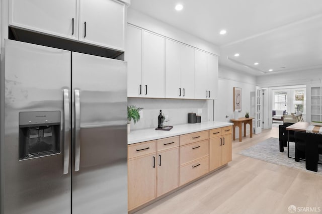 kitchen featuring stainless steel fridge, light wood finished floors, light countertops, light brown cabinets, and recessed lighting