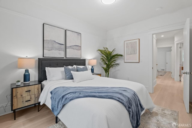 bedroom with wood finished floors, baseboards, and recessed lighting