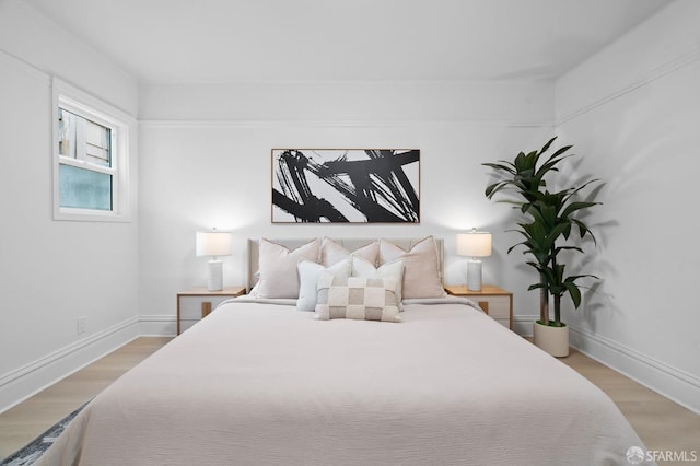 bedroom featuring light wood-style floors and baseboards