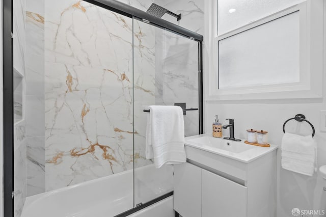 full bath featuring vanity and combined bath / shower with glass door