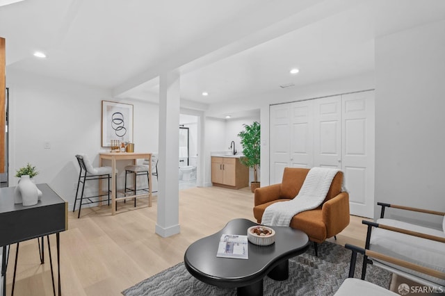 living area with light wood-style floors, recessed lighting, and baseboards