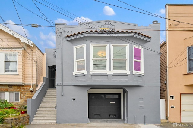 view of front of house with stucco siding and a garage