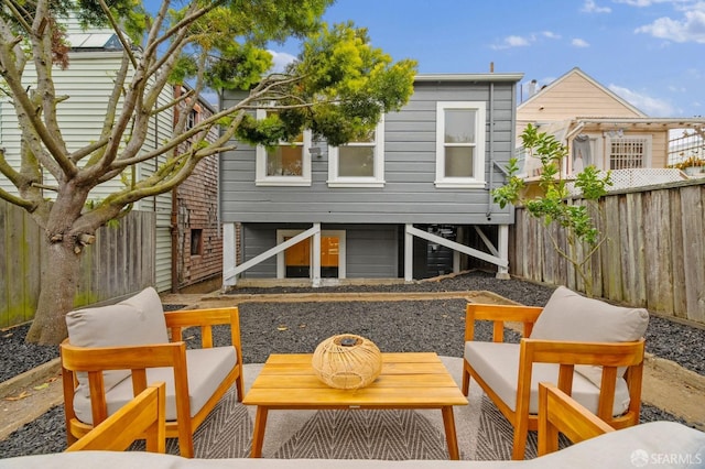 back of house with a fenced backyard and an outdoor hangout area