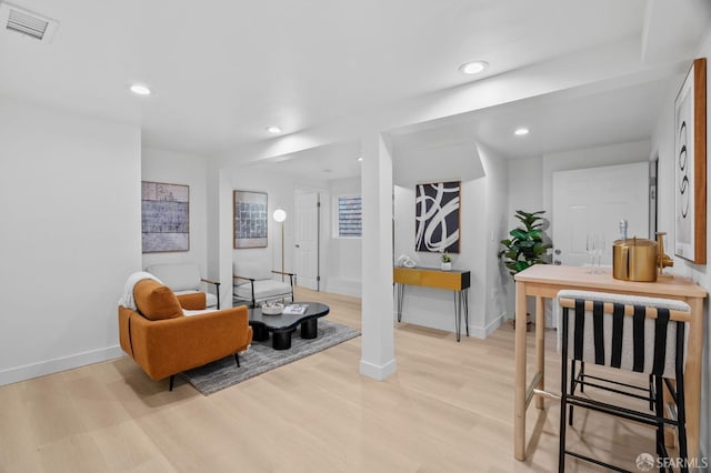 living area with light wood-style flooring, baseboards, and recessed lighting