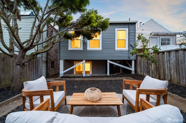 rear view of house with a fenced backyard, an outdoor hangout area, and a patio