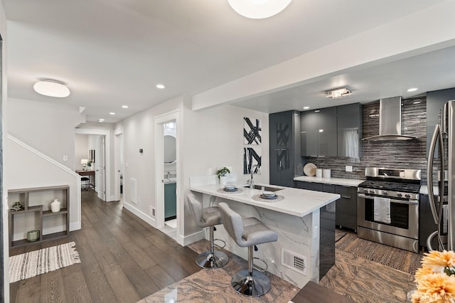 74 Crane St, San Francisco, CA 94124 - kitchen featuring wall chimney exhaust hood, stainless steel appliances, modern cabinets, a kitchen bar, and backsplash