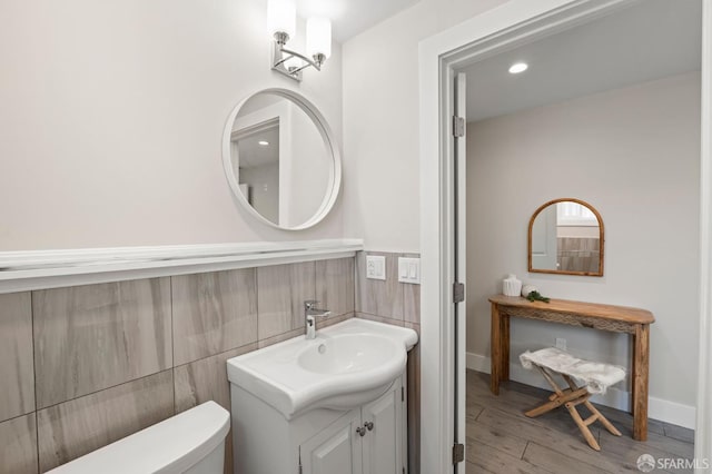 74 Crane St, San Francisco, CA 94124 - bathroom featuring vanity, wood finished floors, toilet, and a wainscoted wall