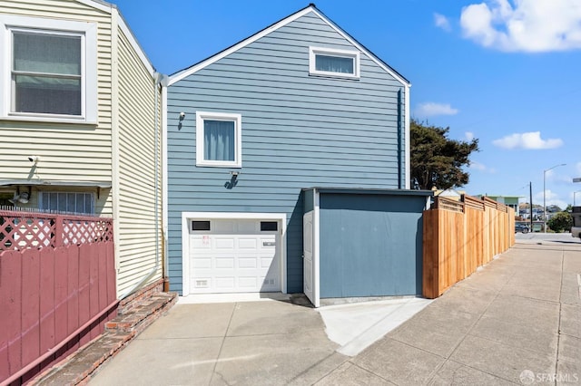 74 Crane St, San Francisco, CA 94124 - view of side of home featuring concrete driveway and an attached garage