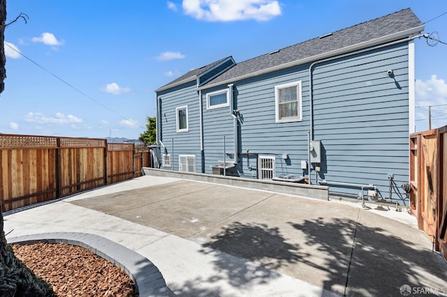 74 Crane St, San Francisco, CA 94124 - rear view of house with a patio area, a fenced backyard, and a shingled roof