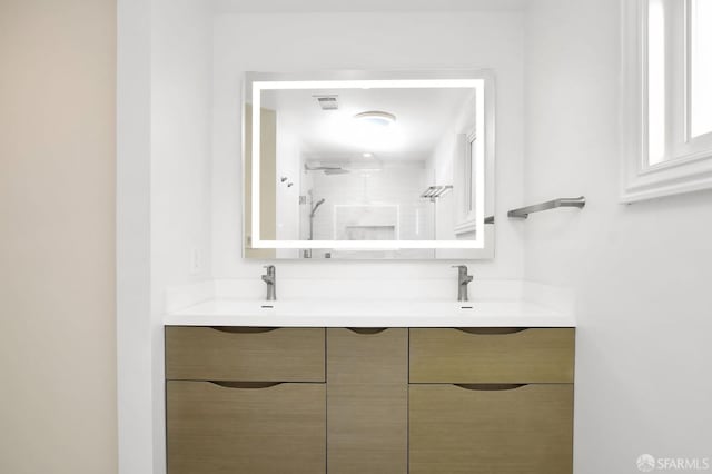 bathroom with vanity and tiled shower