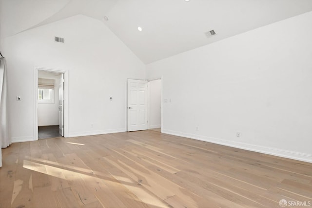 unfurnished bedroom featuring connected bathroom, high vaulted ceiling, and light hardwood / wood-style floors