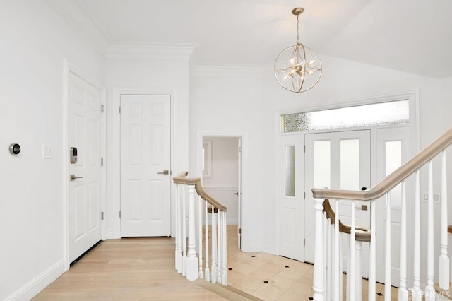 entrance foyer featuring crown molding, light wood-type flooring, and a notable chandelier