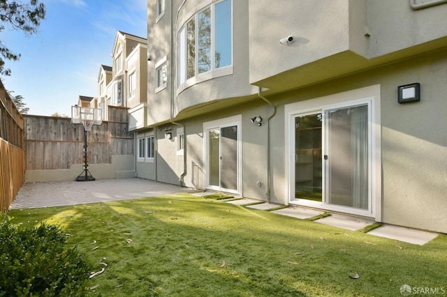 rear view of property with a lawn and a patio area