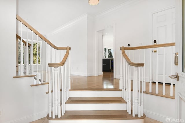 staircase with tile patterned floors and ornamental molding