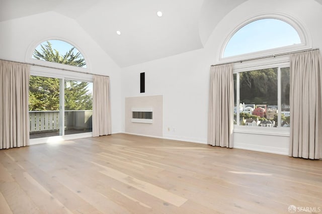 unfurnished living room with high vaulted ceiling and light hardwood / wood-style flooring