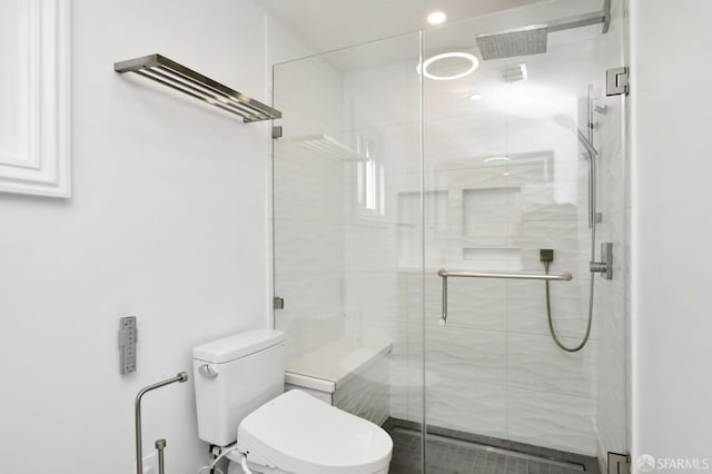 bathroom with toilet and a shower with shower door