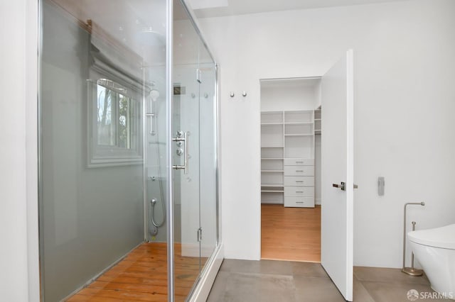 bathroom featuring wood-type flooring and a shower with shower door