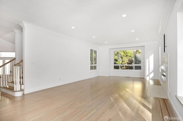 unfurnished living room featuring light wood-type flooring and crown molding