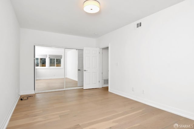 unfurnished bedroom with a closet and light hardwood / wood-style flooring