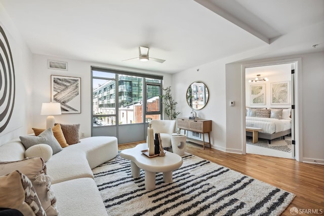 living room featuring wood-type flooring and ceiling fan