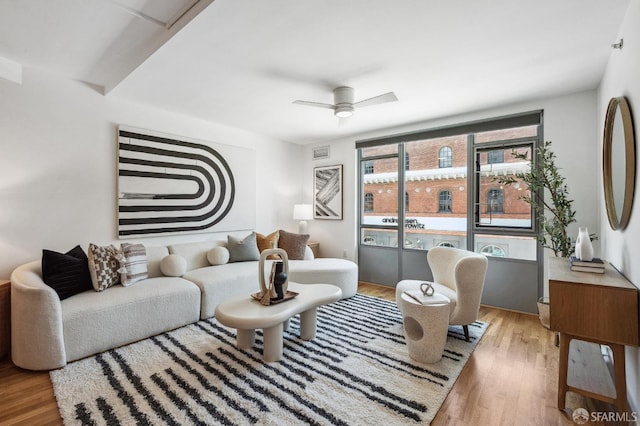 living room featuring ceiling fan and light hardwood / wood-style flooring