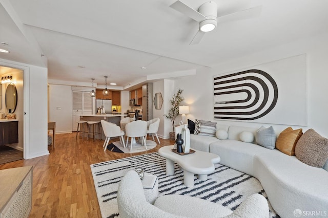 living room featuring ceiling fan and light hardwood / wood-style flooring