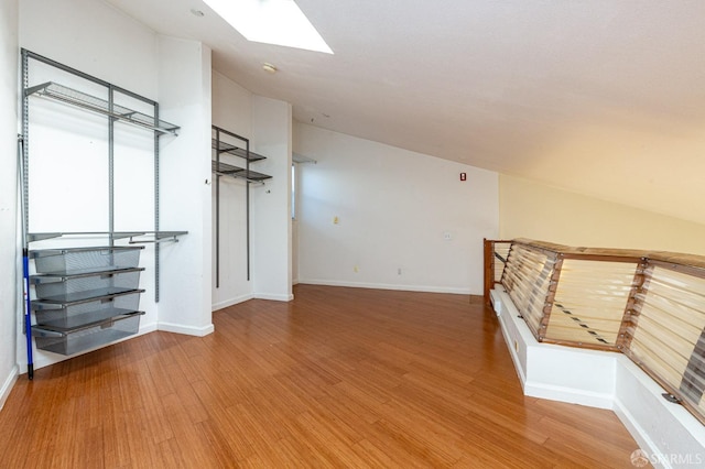 bonus room with wood-type flooring and a skylight